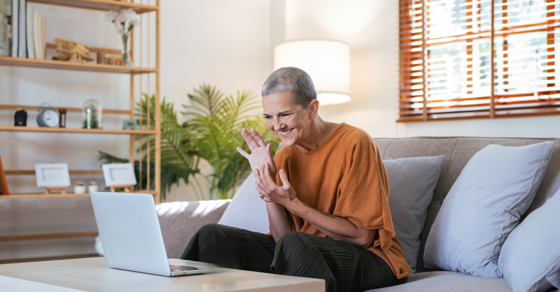 Smiling woman attending an online physiotherapy session via laptop from home