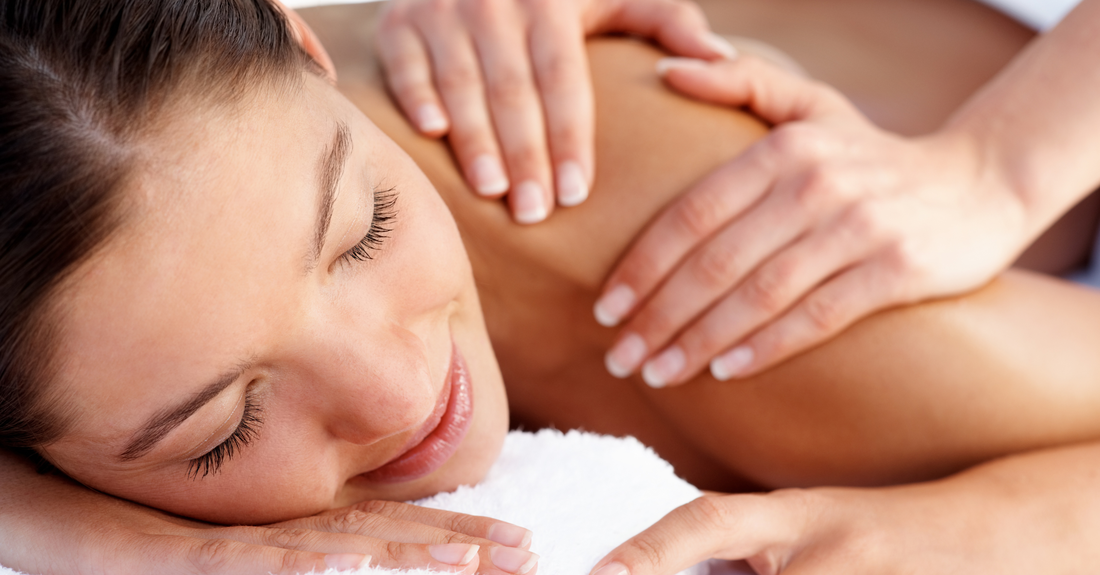 Smiling woman receiving a relaxing shoulder massage at a wellness center