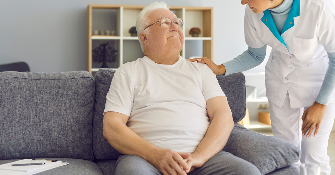 Elderly man receiving home visit care from a healthcare professional