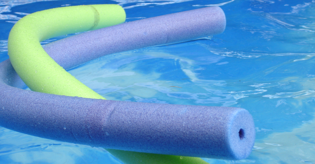Colorful foam pool noodles floating in a therapy pool