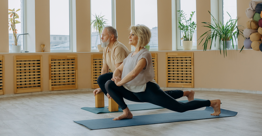 Senior couple doing guided stretching exercises in a bright studio
